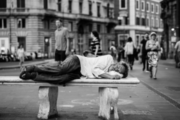 Un homme dors sur un banc